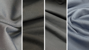 Quatro tecidos técnicos em tons escuros, com variações de textura e caimento, ideais para roupas fitness e esportivas.
