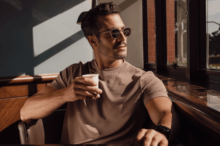 Homem usando camiseta de tecido tecnológico em ambiente urbano sofisticado, ilustrando elegância, conforto e inovação têxtil da Diklatex.