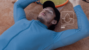 Homem descansando em quadra de tênis com camisa esportiva azul em tecido Diklatex com tecnologia Truelife® Dry, que garante secagem rápida e conforto durante atividades físicas.