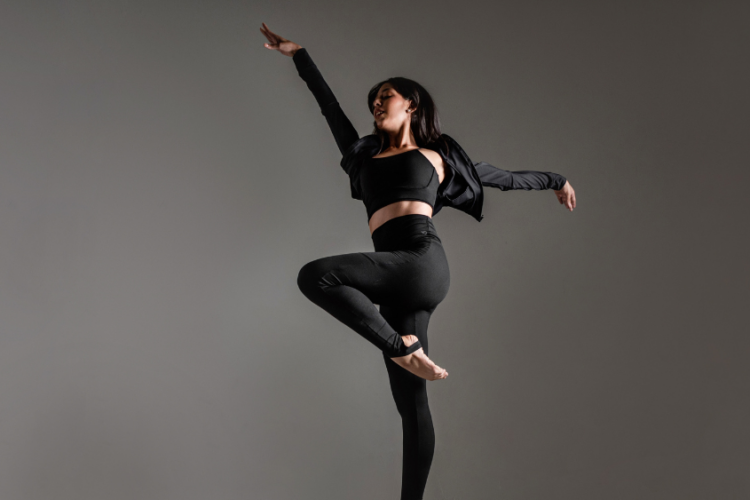 Mulher em movimento usando roupa esportiva preta de alta performance, ilustrando como a indústria têxtil pode reduzir o consumo de água com tecidos tecnológicos sustentáveis.