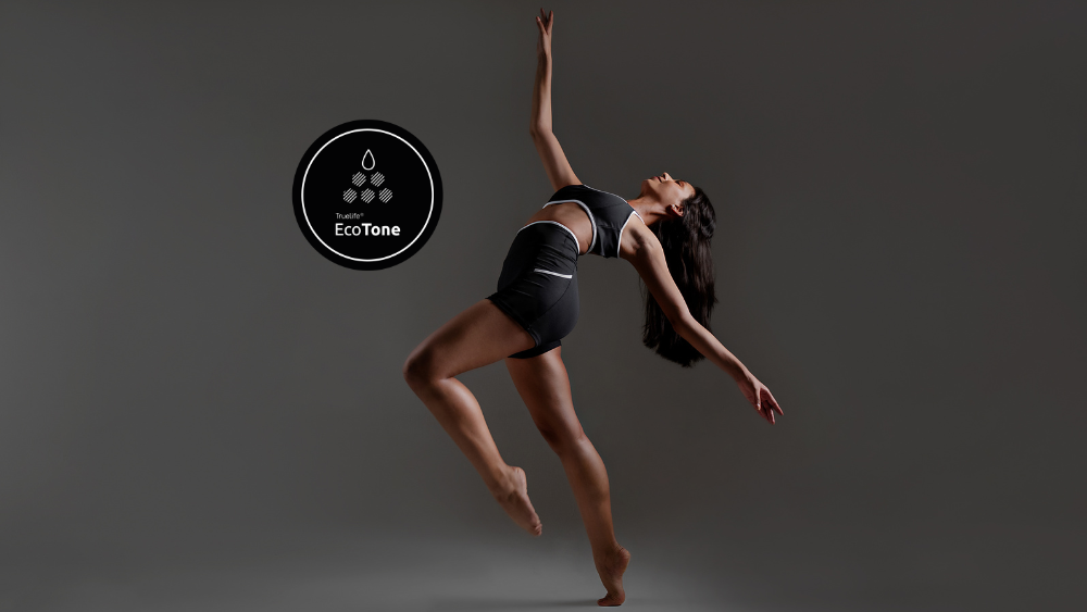 Bailarina em movimento usando roupa esportiva com tecnologia EcoTone, tecido sustentável com Dope Dyeing de menor impacto ambiental