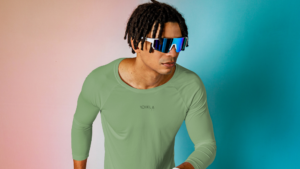 Homem usando camiseta esportiva verde de alta performance, desenvolvida com tecido técnico para activewear, com foco em conforto, elasticidade e controle de umidade.