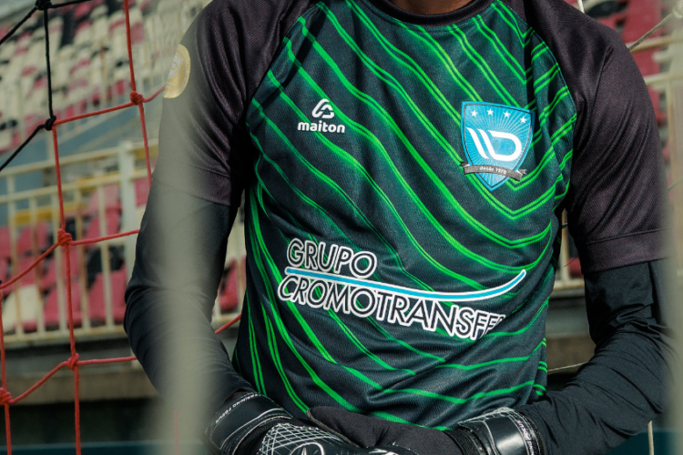 Atleta usando camisa esportiva preta com detalhes verdes em quadra, destacando tecido tecnológico desenvolvido para conforto, respirabilidade e performance esportiva.