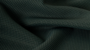 Close-up de tecido tecnológico esportivo com textura tridimensional e estrutura em relevo, desenvolvido para proporcionar conforto, respirabilidade e desempenho em roupas esportivas.
