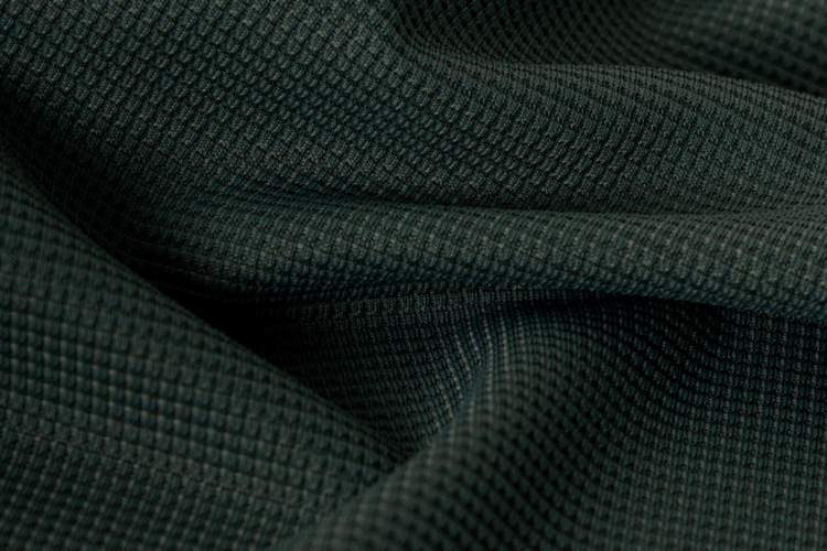 Close-up de tecido tecnológico esportivo com textura tridimensional e estrutura em relevo, desenvolvido para proporcionar conforto, respirabilidade e desempenho em roupas esportivas.