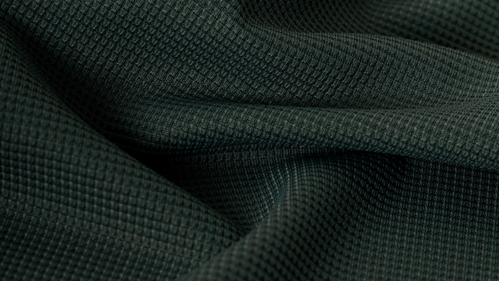 Close-up de tecido tecnológico esportivo com textura tridimensional e estrutura em relevo, desenvolvido para proporcionar conforto, respirabilidade e desempenho em roupas esportivas.