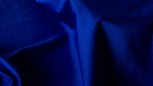 Close-up de tecido esportivo azul com textura técnica, destacando sua estrutura e acabamento voltados para durabilidade, conforto e caimento.