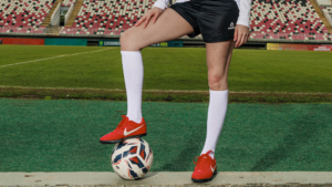 Jogadora com uniforme de futebol em campo demonstrando como o tecido impacta a performance no futebol com conforto, mobilidade e leveza.