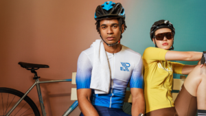 Atletas usando roupa esportiva profissional para ciclismo, com tecidos técnicos de alta performance que oferecem conforto, respirabilidade e liberdade de movimento.