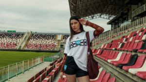 Mulher em estádio usando streetwear tecnológico que combina moda urbana, conforto e performance.