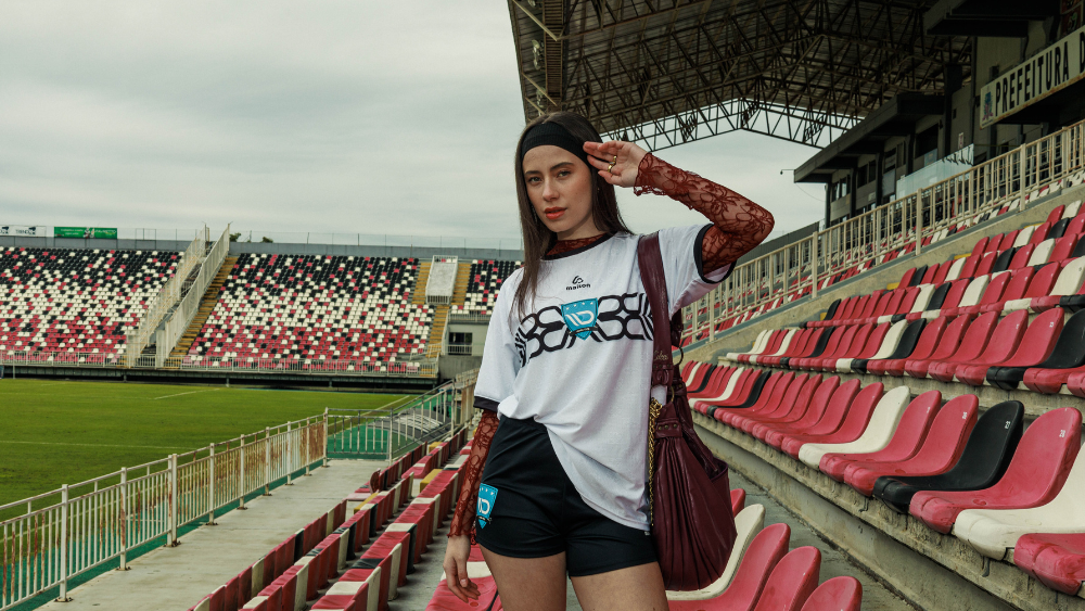 Mulher em estádio usando streetwear tecnológico que combina moda urbana, conforto e performance.