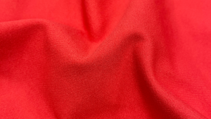 Tecido esportivo vermelho com textura e caimento para roupas de alta performance.