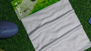 Tecido para camisa de futebol profissional sobre gramado, com construção jacquard e textura esportiva.